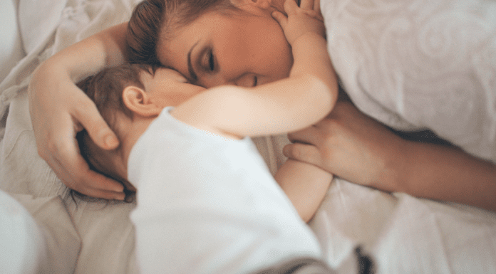 A baby holding his mother's face.