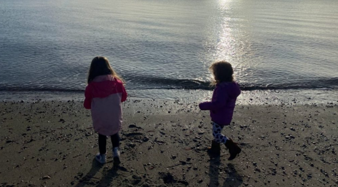 Two girls running on the beach.