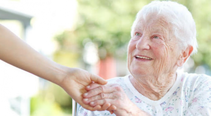 An older woman reaching out to grab a hand.