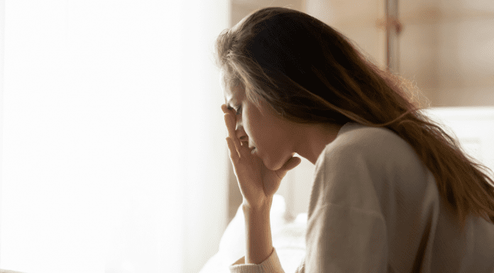 A sad woman holding her face.
