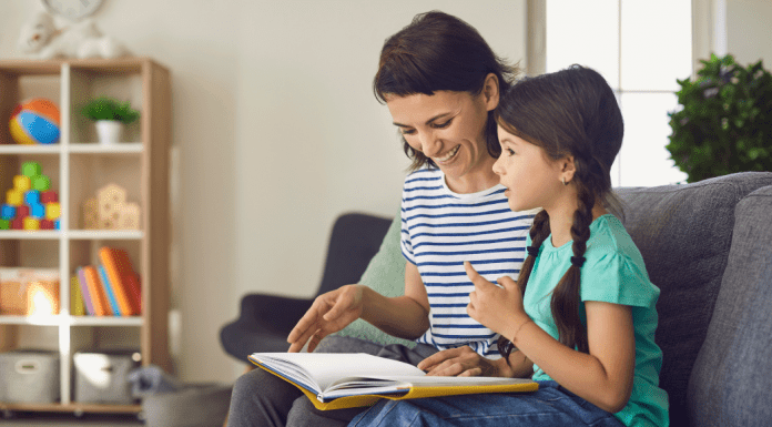A daughter asking her mom questions as they look at a book.