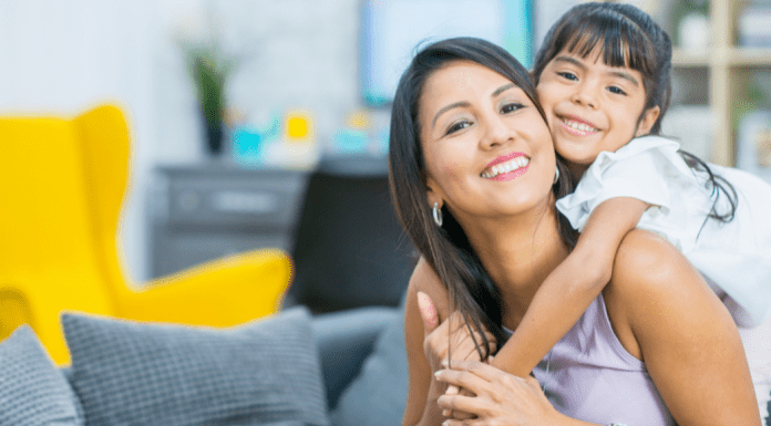 A daughter holding her mom from behind.