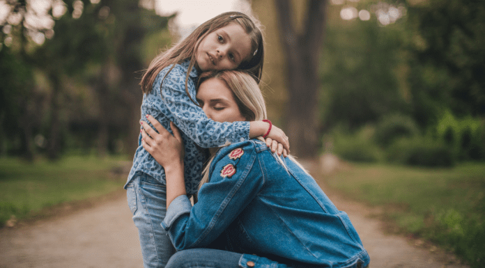 A mom and daughter hugging.