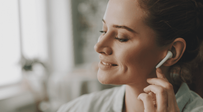 A woman listing to a true crime podcast on her earbuds.