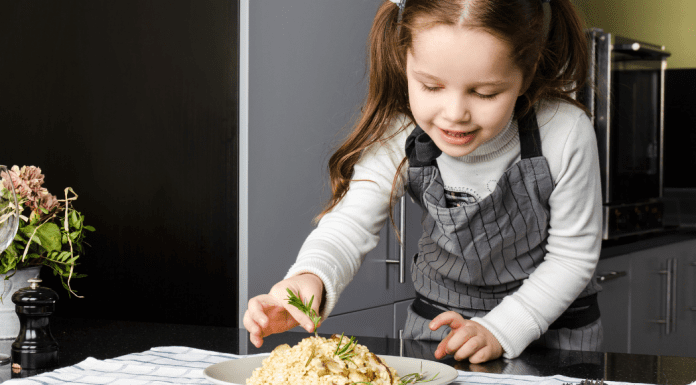 A little girl preparing a meal.
