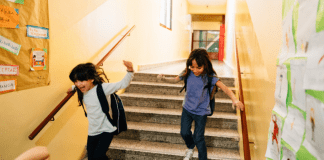 Two students racing down the school stairs.