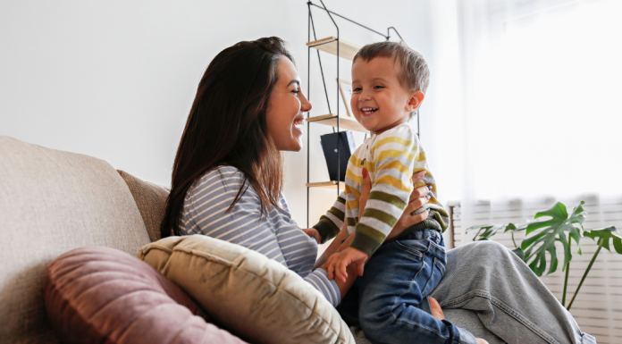 A mom holding a toddler on the couch.