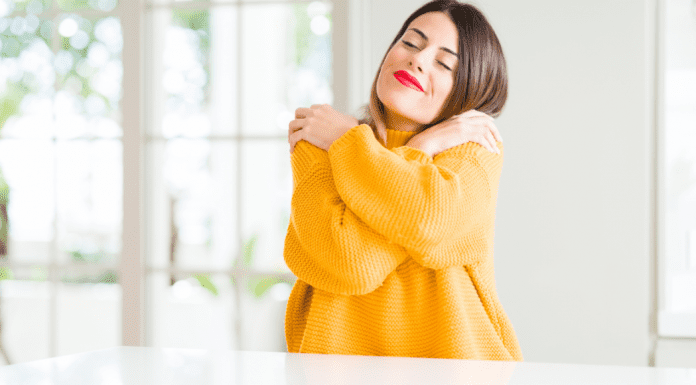 A woman hugging herself.