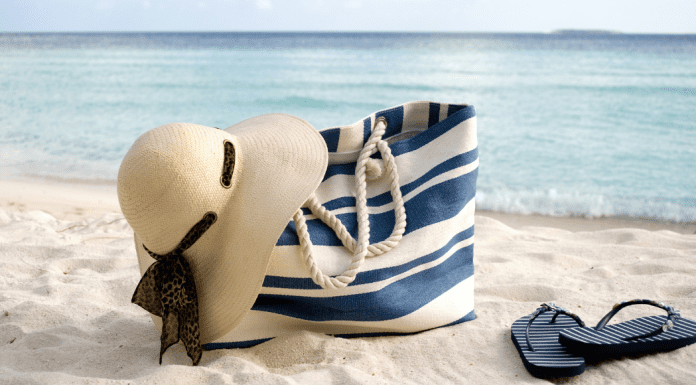 A full beach bag on the sand.