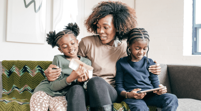 A mom with her arms around her children.