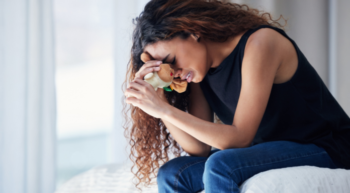 A woman crying holding a stuffed animal.