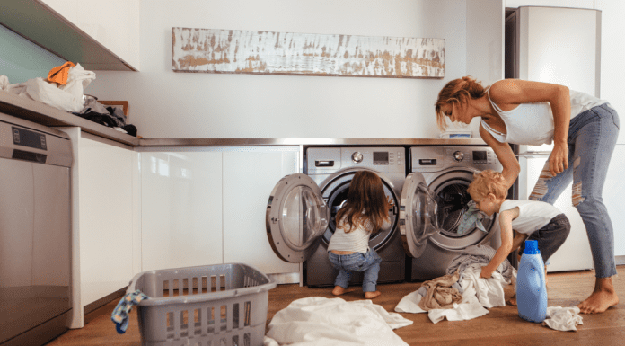 A mom doing laundry with her children.