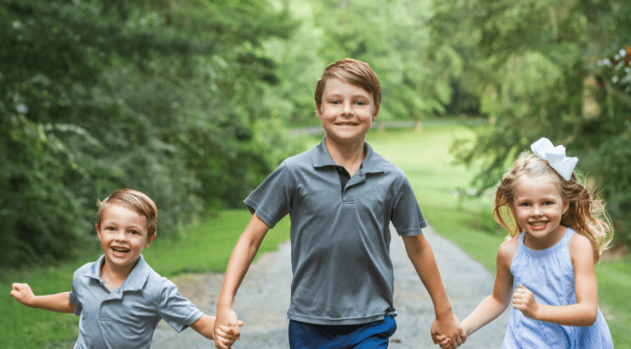Three siblings holding hands.