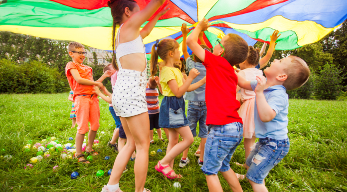 Kids playing under a parachute.