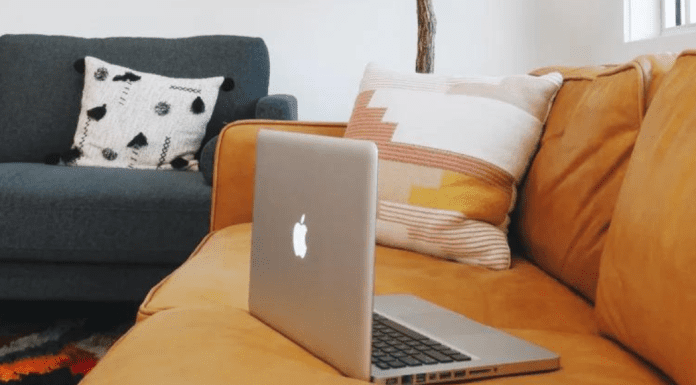 A computer resting on a couch.