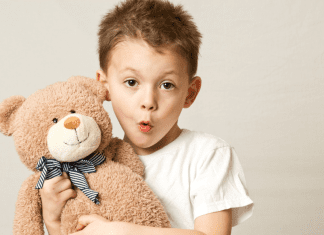 A boy hugging his teddy bear.