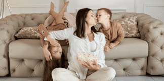 A mom holding and kissing her children.