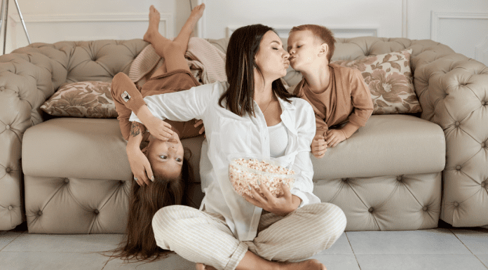A mom holding and kissing her children.