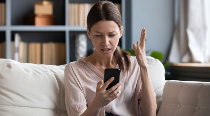 A frustrated woman looking at her phone.