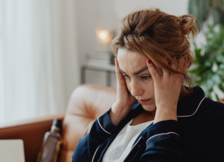 A stressed woman holding her head.