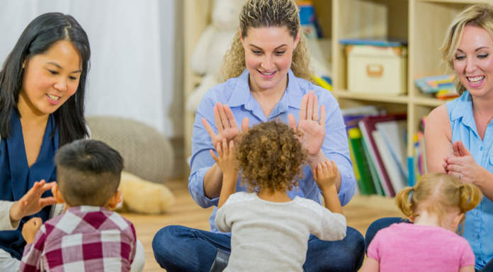 Moms clapping hands with their toddlers at a Mommy and Me class.