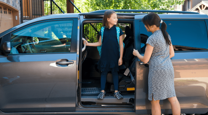 A mom getting the kids in a minivan.