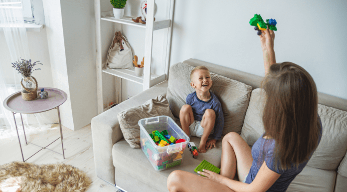 A mom playing pretend with a toy car.