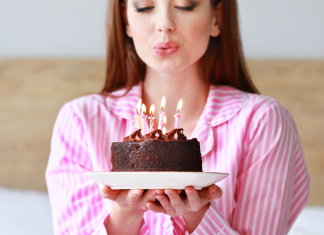 A woman blowing out birthday candles.