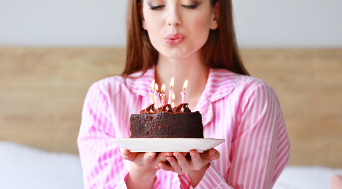 A woman blowing out birthday candles.