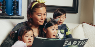 A mom reading a book to her children.