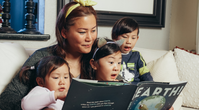 A mom reading a book to her children.