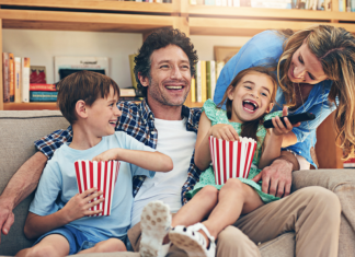 A family eating popcorn and watching a movie.