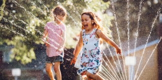 Kids running through a sprinkler.