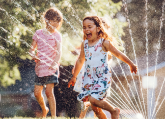 Kids running through a sprinkler.
