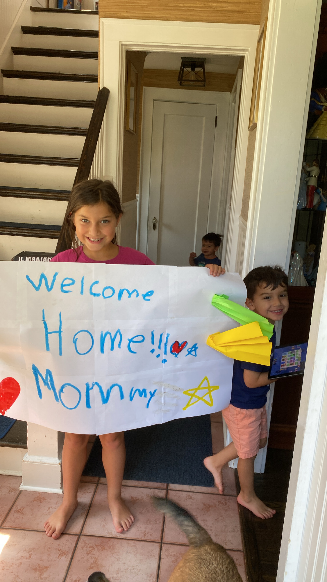 Kids holding a welcome home sign.