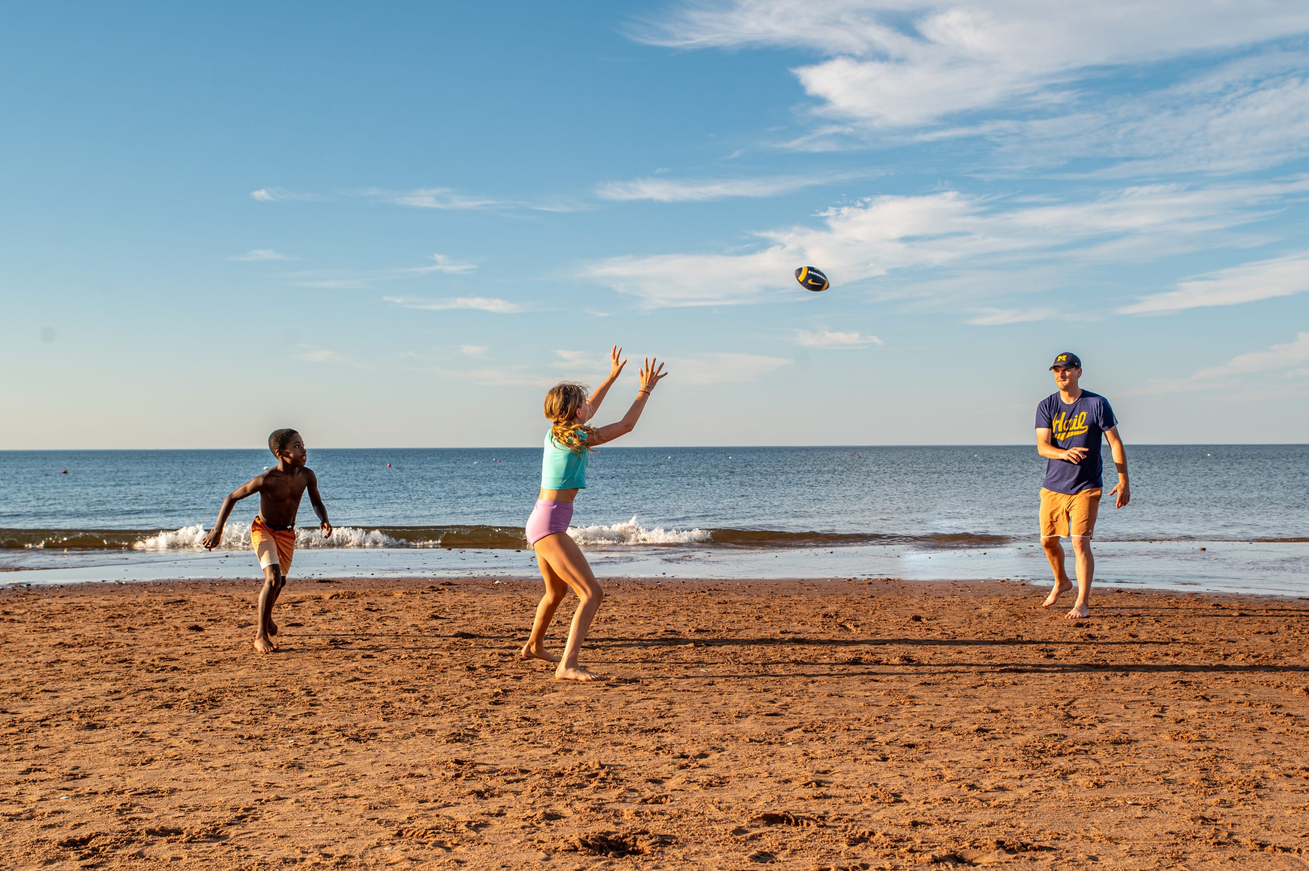 Kids playing football on the beach.