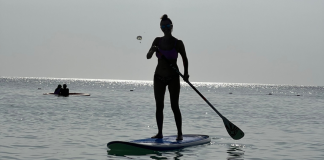 A woman paddleboarding.