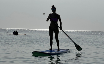 A woman paddleboarding.