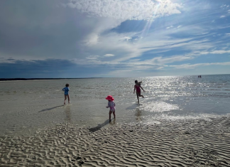 Children running during low tide at the beach.