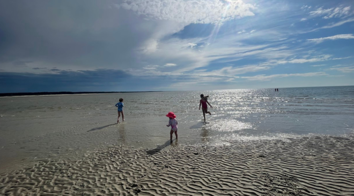 Children running during low tide at the beach.