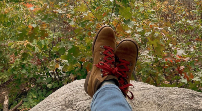 Feet resting on a large boulder in the woods.