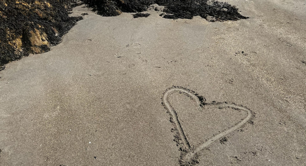 A heart drawn in the sand.