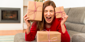 A stressed woman holding holiday gifts.