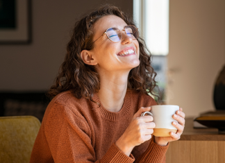 A happy woman holding a cup of coffee.