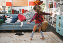A child dancing in a chaotic living room.