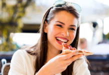 A woman eating a slice of pizza.