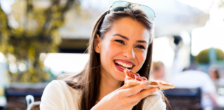 A woman eating a slice of pizza.