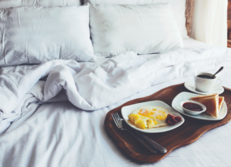 A bed with breakfast on a tray.