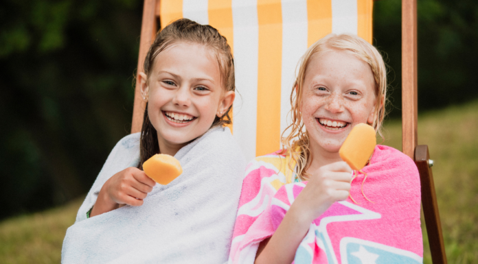 Girls wrapped in towels eating popsicles.