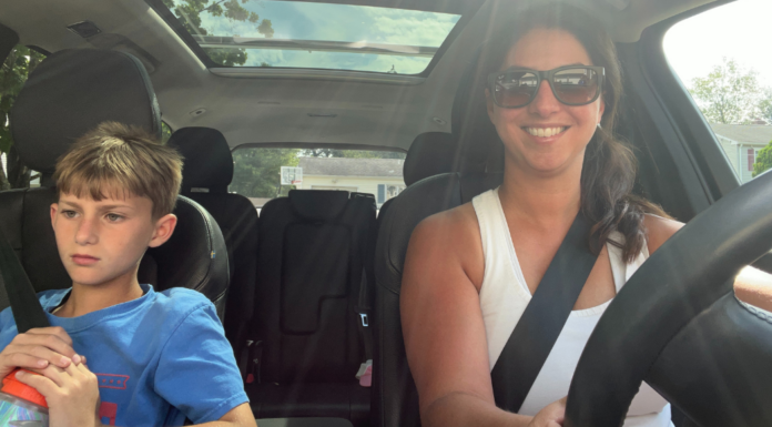 A mom driving her son in the car.